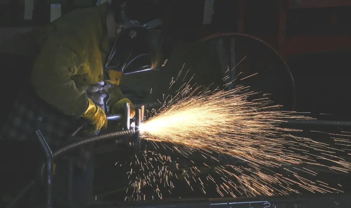 Manufacturing worker grinding metal in a factory
