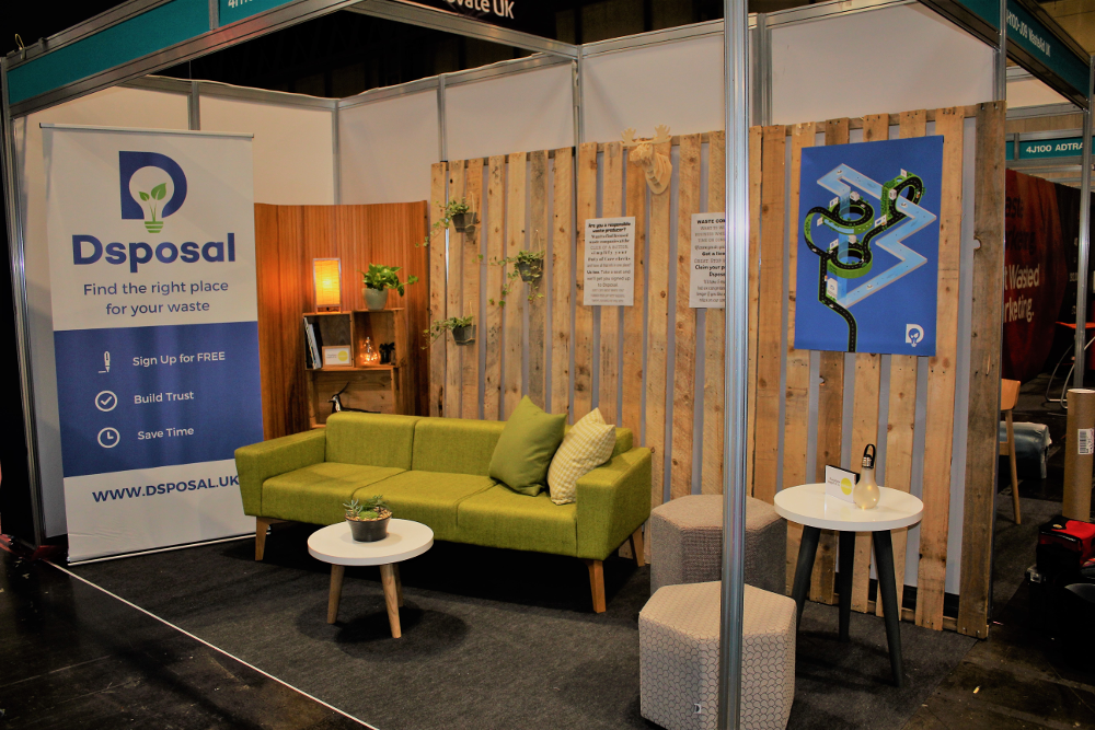 Photograph of Dsposal's lifestyle exhibitor stand at RWM 2018. Comfortable office furniture with wood paneling and Dsposal branding